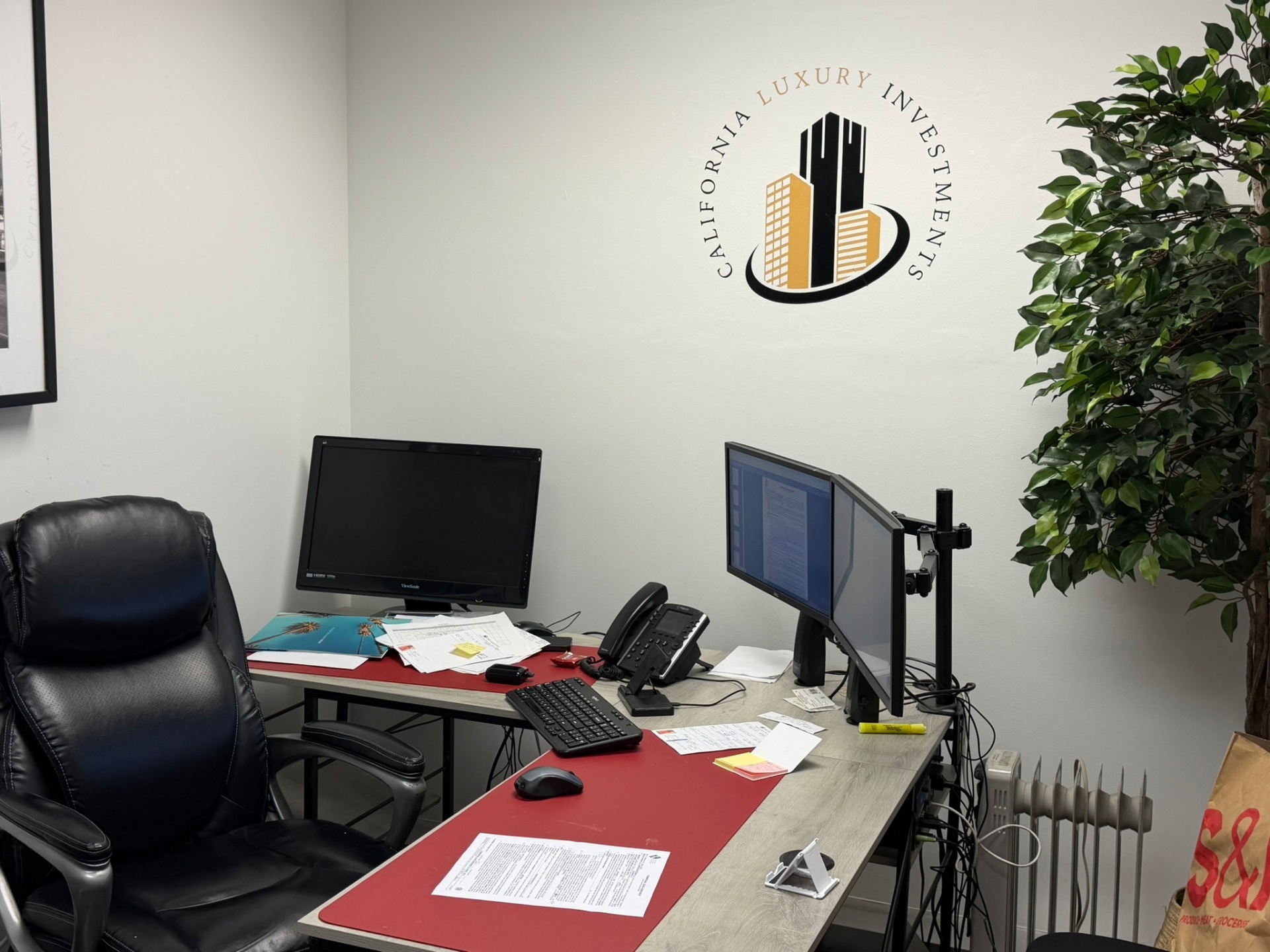 Shahram Shamounpour's private office at California Luxury Investments — branded workspace with dual monitors.